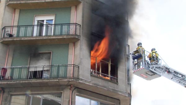Os bombeiros intervindo para sofocar o lume nun edificio do centro de Ourense./ Foto: Luis Baños.